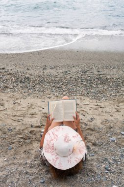 Kadın portre rahatlatıcı sahilde kitap okurken