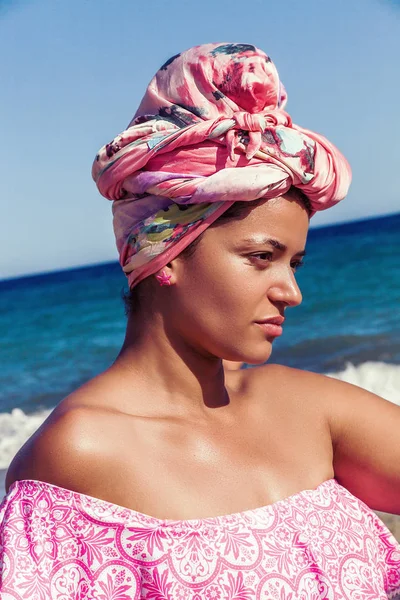 Hermoso retrato de mujer con camisa rosa y turbante en la playa — Foto de Stock