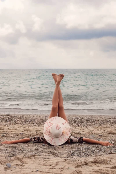 Porträt einer Frau, die am Strand die Beine hochlegt — Stockfoto