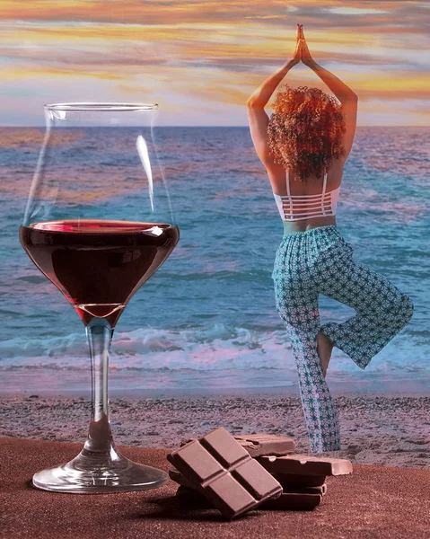 Rødvinsglass med sjokolade og kvinne som øver på yoga med fargerik solnedgang – stockfoto