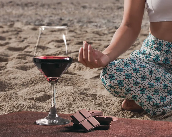 Çikolata ve pratik yoga sahilde kadın ile Şarap kadehi
