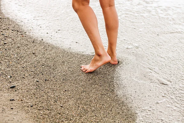 Pernas de mulher, andando na praia — Fotografia de Stock