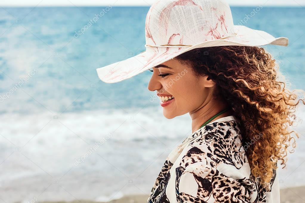 Beautiful and fashionable woman smiling in front of the sea, Summer vacations