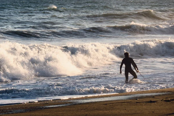 Silhouette surfista sulla spiaggia e onde del mare — Foto Stock