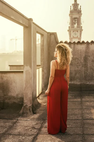 Beautiful woman back portrait wearing red dress and looking aside — Stock Photo, Image