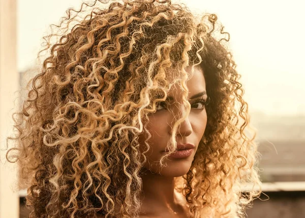 Beautiful woman with gorgeous curly hair in the sunlight — Stock Photo, Image