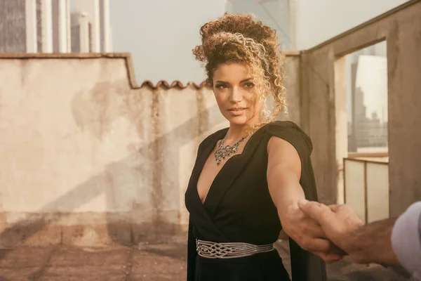 Pretty and elegant woman portrait hand in hand with her lover on building roof — Stock Photo, Image