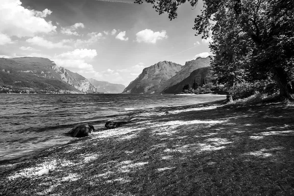 Beautiful glimpse of Lake Como, Italy, with stone beach - Monochrome — Stock Photo, Image