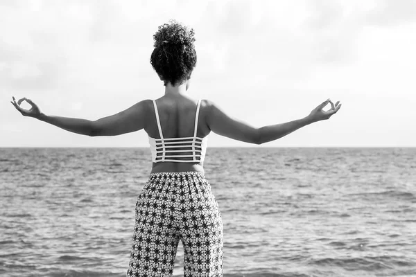 Krásná mladá žena při pohledu na moře a meditaci, černá a bílá — Stock fotografie