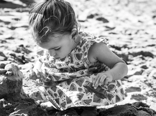 Bonito retrato menina brincando com brinquedos de areia, preto e branco — Fotografia de Stock