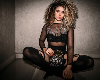 Şeffaf gömlek ve holding hip hop kap oturma iken giyen güzel kadın