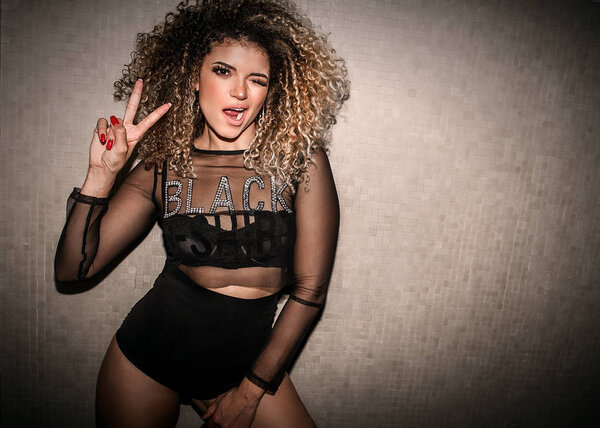 Beautiful and transgressive woman portrait making victory sign and winking