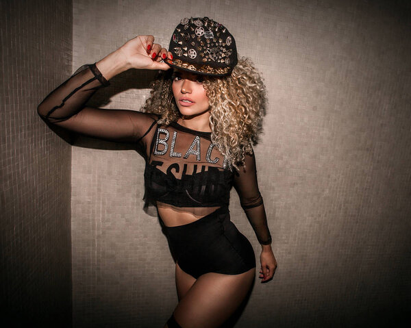 Beautiful woman portrait wearing transparent shirt and wearing hip hop cap while posing