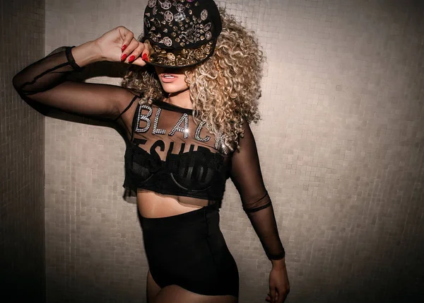 Beautiful woman wearing transparent shirt and wearing hip hop cap while posing — Stock Photo, Image