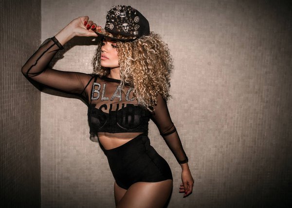 Woman portrait wearing transparent shirt and wearing hip hop cap while posing