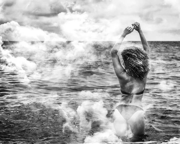 Doppia esposizione della donna che fa il bagno nel mare e nel paesaggio nuvoloso, monocromatico — Foto Stock