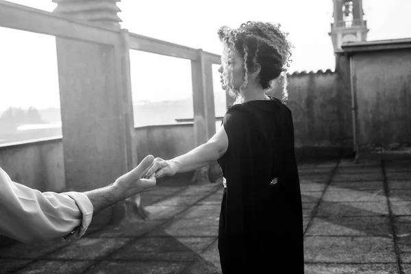 Elegante mujer de nuevo retrato de la mano con su amante en el techo del edificio, monocromo — Foto de Stock