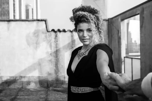 Elegante retrato de mujer mano a mano con su amante en el techo del edificio, monocromo — Foto de Stock