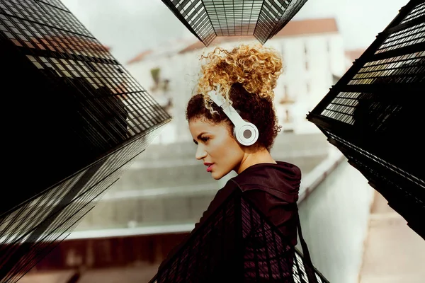 Double exposure of sporty woman portrait listening to music and skyscrapers — Stock Photo, Image