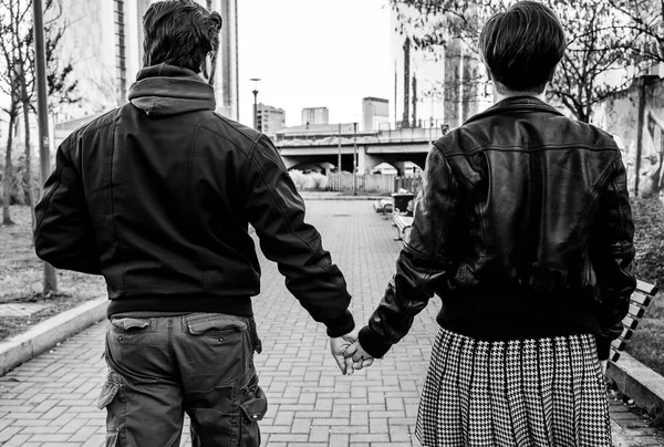 Hermoso retrato de pareja tomados de la mano en la ciudad mientras caminan juntos, monocromo —  Fotos de Stock
