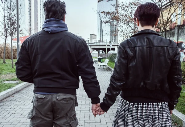 Beautiful couple portrait holding hands in the city while walking together — Stock Photo, Image