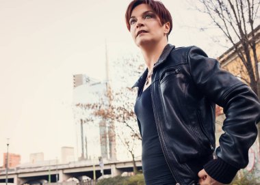 Güzel kadın portre deri ceket giyiyor ve ararken şehirde