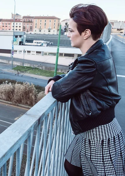 Beautiful woman portrait wearing leather jacket and skirt in the city — Stock Photo, Image