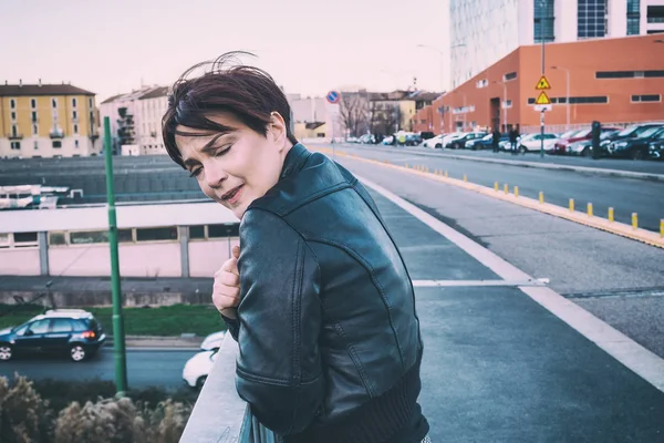 Portret van de vrouw een koud gevoel in de stad tijdens winderige dag — Stockfoto