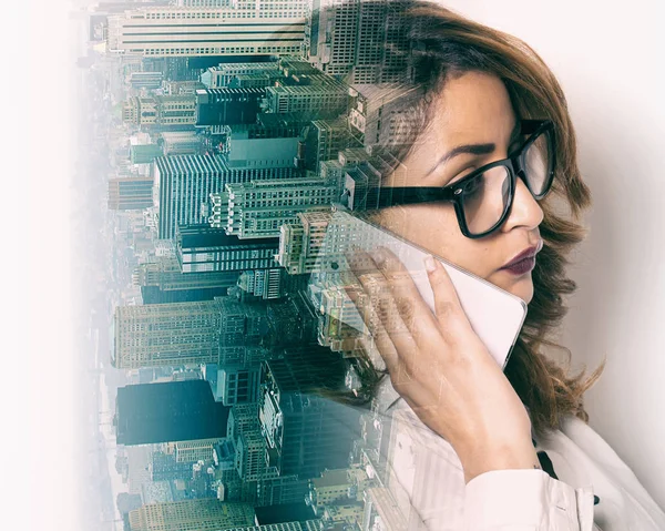 Double exposure of businesswoman making phone call and city skyline — Stock Photo, Image