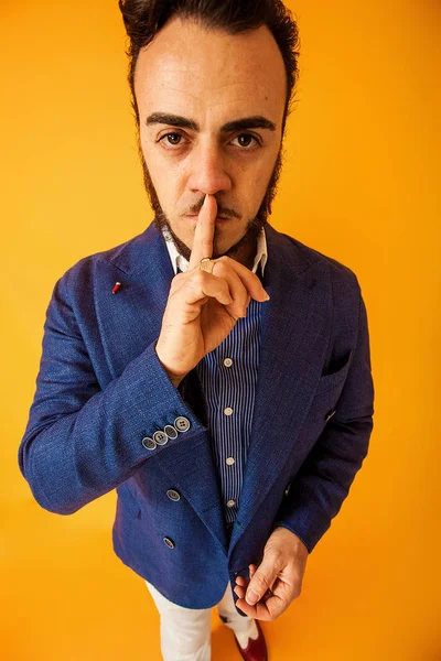 Retrato divertido del hombre con el dedo en los labios, gesto de silencio — Foto de Stock