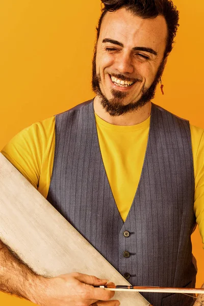 Hombre primer plano retrato sosteniendo musical sierra y sonriendo ampliamente — Foto de Stock