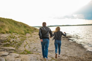 couple runs along the lake as supermen
