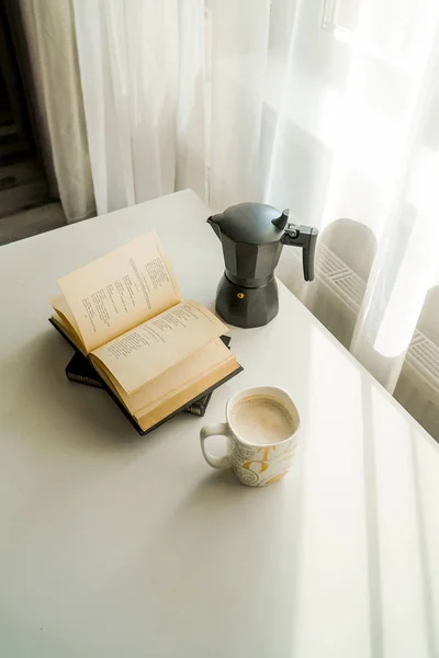 geyser coffee maker, coffee and book