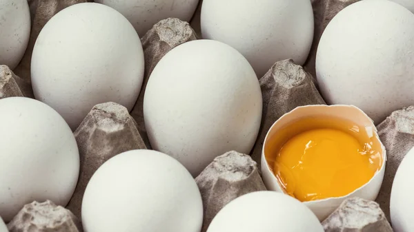 Tavuk yumurtası diğer yumurtaların yanında yarısı kırıktır. — Stok fotoğraf