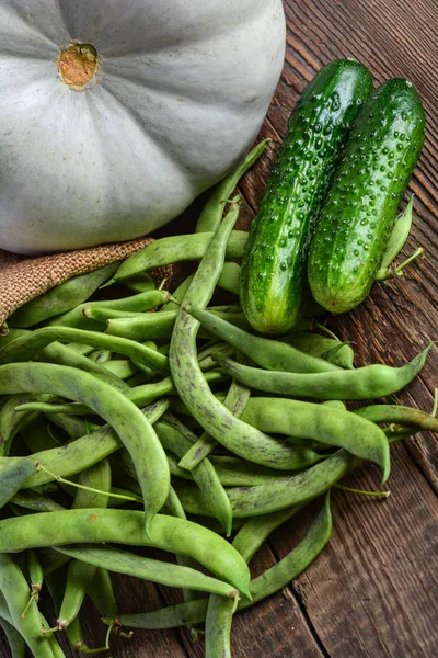Zelené fazole lusky, okurky a dýně na dřevěný povrch — Stock fotografie