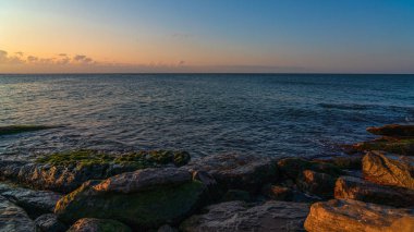 Gün batımından sonra kayalık deniz kıyıları