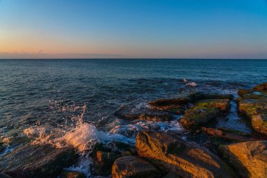 Gün batımından sonra kayalık deniz kıyıları