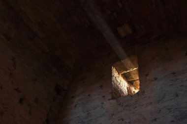 Eski taş bir kalenin penceresindeki ışık huzmesi