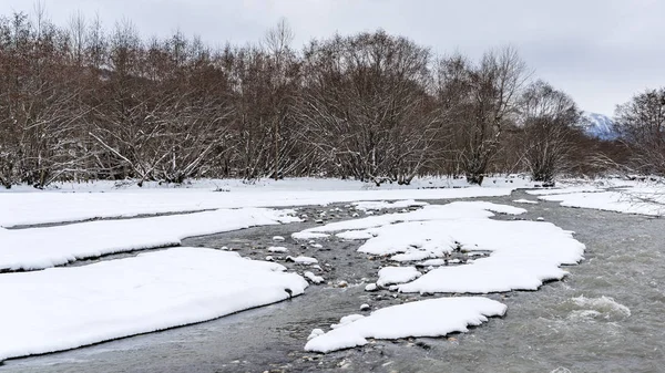 Rivière de montagne en hiver, couverte de neige — Photo