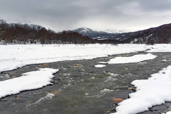 Rivière de montagne en hiver, couverte de neige — Photo