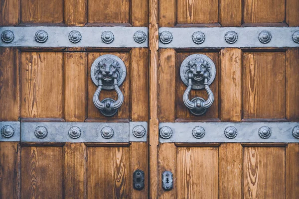 Puerta de madera antigua con llamadores —  Fotos de Stock