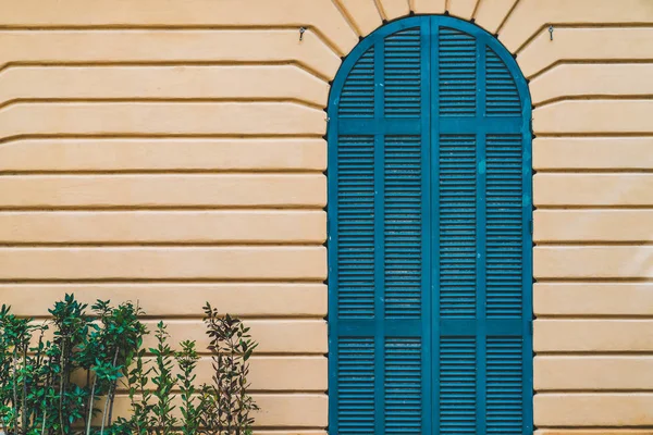 Kék íves ajtó a sárga falon — Stock Fotó