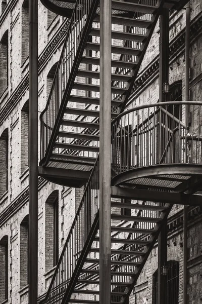 Exterior metal stairs of an old restored factory in warm black and white