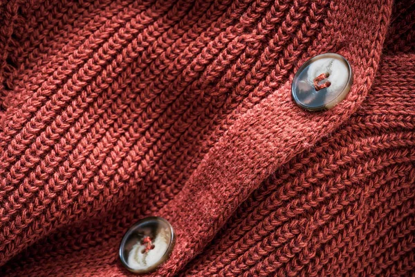 Buttons of a natural wool knitted cardigan