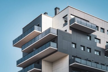 Balkon ve pencerelerle dolu bir binanın geometrik cephesi