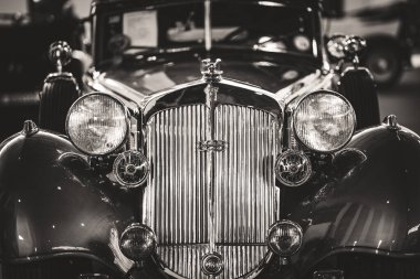 Siyah beyaz bir Cabriolet spor arabasının ızgara ve farlarının ön detayları.