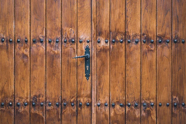 鉄のスタッドで飾られた伝統的な木製のドア — ストック写真