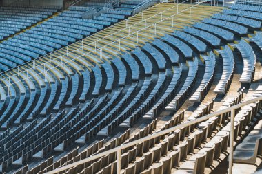 Güneşli bir günde spor müsabakasından önce büyük bir stadyumun boş koltukları.