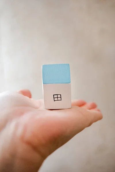 Mão Segurando Uma Pequena Casa Madeira Branca Azul — Fotografia de Stock