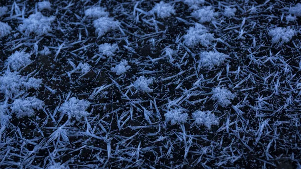 Buzun üzerinde mavi bir buz tabakası, kar taneleri dokusu